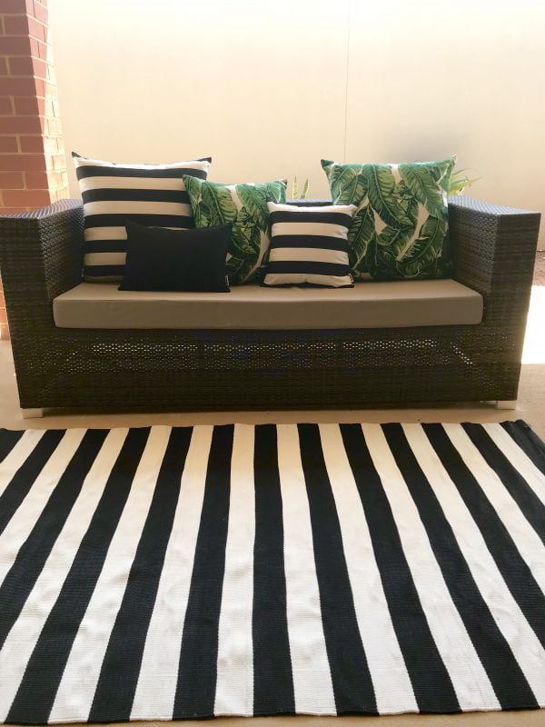 Nantucket Black outdoor rug with Maui Green and Positano Black outdoor cushions